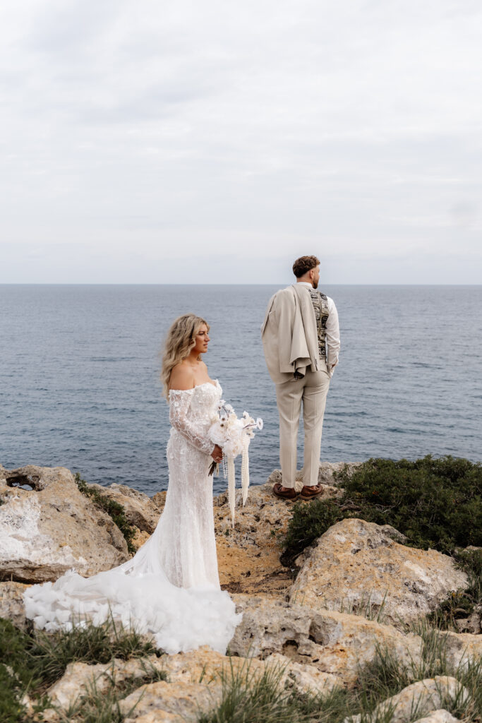 Brautpaar von hinten und seitlich bei After-Wedding-Shooting auf Felsen Mallorca